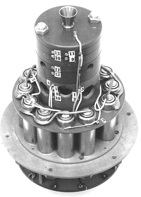 Explorer 1 high-power transmitter: a taller cylindrical unit with numbered terminals and wiring above a ring of battery cells