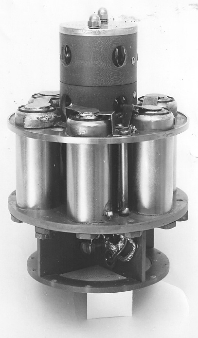 Explorer 1 low-power transmitter: a cylindrical unit ringed with battery cells on a circular plate